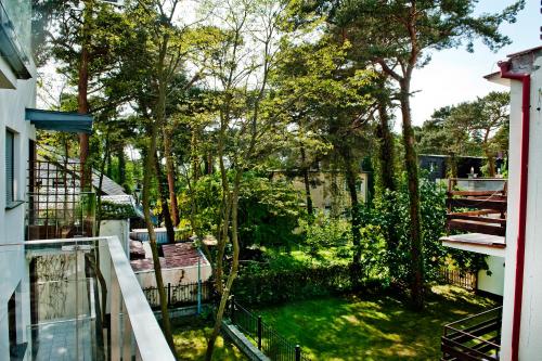 a balcony with a view of a yard with trees at Villa Aqua BlueApart Jurata in Jurata