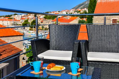 einen Tisch mit einem Teller Essen auf dem Balkon in der Unterkunft Sea Pearl Residence - Top beachfront location apartments in Bol centre in Bol