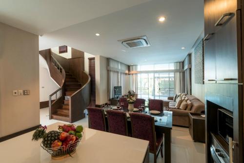 a kitchen and living room with a table with a bowl of fruit at Tropical Garden Paradise Villa in Na Jomtien