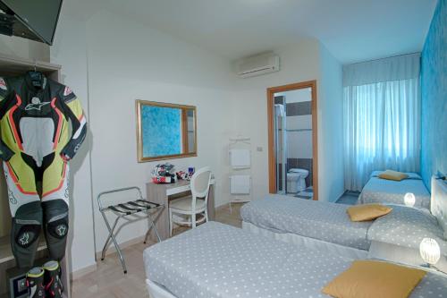 a bedroom with two beds and a desk with a table at Locanda San Biagio in Misano Adriatico