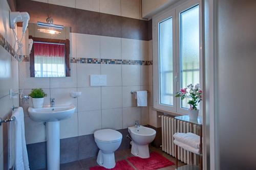 a bathroom with a sink and a toilet and a window at Locanda San Biagio in Misano Adriatico