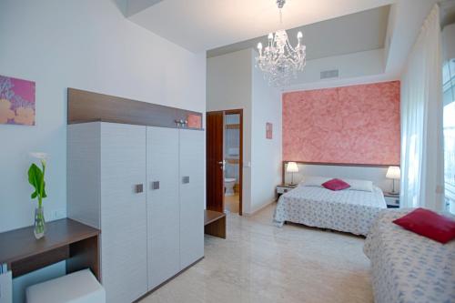 a bedroom with a bed and a desk and a chandelier at Locanda San Biagio in Misano Adriatico