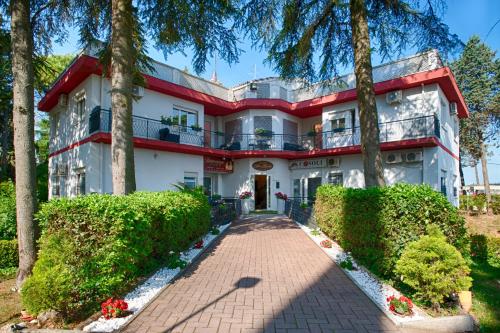 a large white house with trees in front of it at Locanda San Biagio in Misano Adriatico