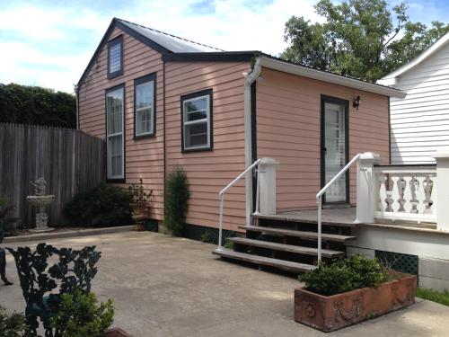 a pink house with a porch and stairs at Stone House Musical B&B in Natchez