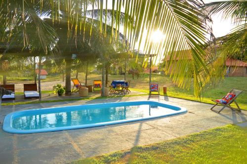 a swimming pool in a yard with a palm tree at Pousada Theodora in Macapá