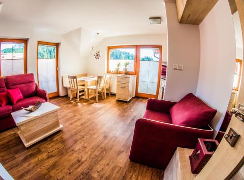 a living room with two red couches and a table at Apartments BBI in Luče