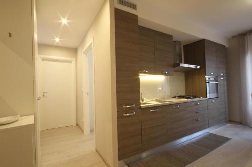 uma cozinha com armários de madeira e um lavatório em Appartamenti al Rizzo dei Santi em Lovere