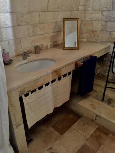 a bathroom with a sink and a mirror at Trulli di Pozzomasiello in Locorotondo