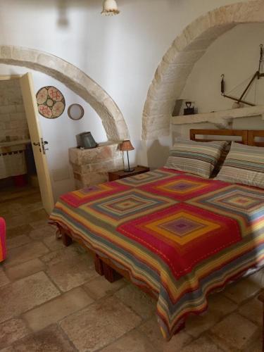 a bedroom with a large bed in a stone room at Trulli di Pozzomasiello in Locorotondo