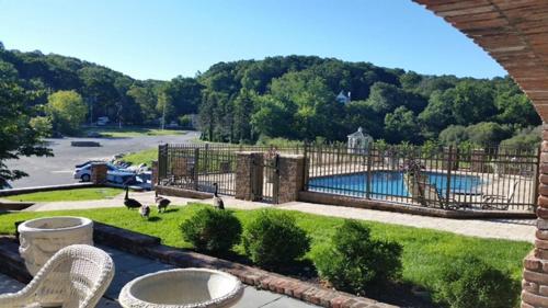 een patio met een hek en een zwembad bij Chalet Inn & Suites in Centerport