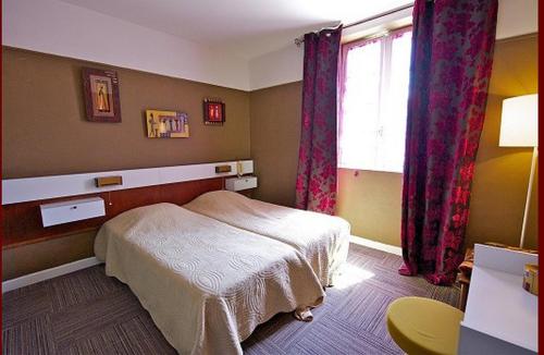 a bedroom with a bed and a window at Hôtel Restaurant Le Pain de Sucre in Monistrol-dʼAllier