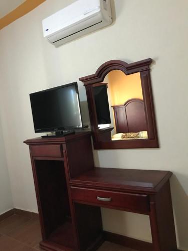 a dresser with a television and a mirror at Hotel Campo Real Plus Tamasopo in Tamasopo