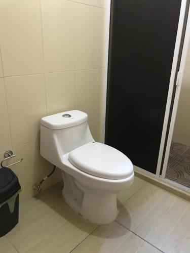a white toilet in a bathroom with a shower at Hotel Campo Real Plus Tamasopo in Tamasopo