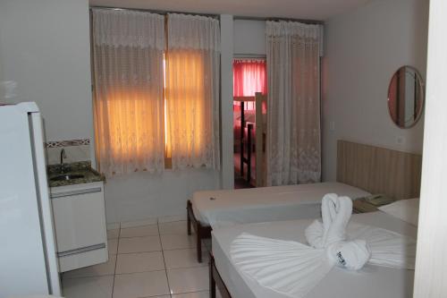 a small room with two beds and a kitchen at Apart Service Araras - VPC in Caldas Novas