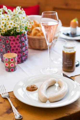a table with a plate of donuts and a glass of wine at Genießerhotel Döllerer in Golling an der Salzach