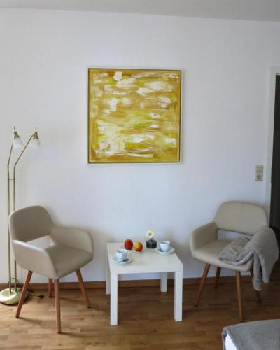 a living room with a table and two chairs and a painting at Haus von Hoegen in Cochem
