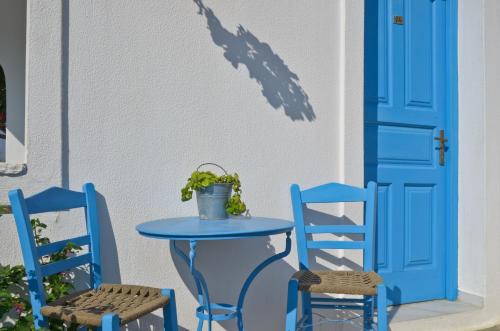 a blue table and two chairs and a blue door at Dilino Hotel Studios in Agios Prokopios