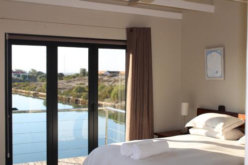 a bedroom with a bed and a view of the water at Island Style in Velddrif