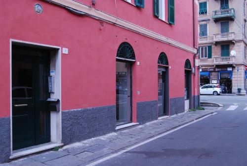 a red building on the side of a street at Casa MaMa Guesthouse in Genova