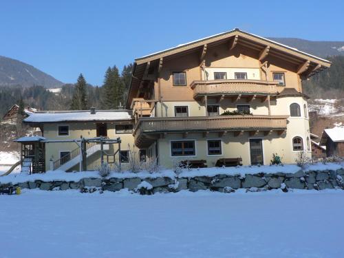 a large house with snow in front of it at Bio-Bauernhof Obertrattenbachhof in Neukirchen am Großvenediger