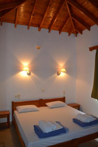 Molivos Castle Apartments في ميثيمنا: غرفة نوم عليها سرير وفوط