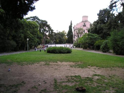 a park with people walking and a building in the background at Casa MaMa Guesthouse in Genova
