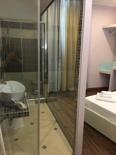 a bathroom with a shower, sink, and mirror at Antico Hotel Moderno in Piombino