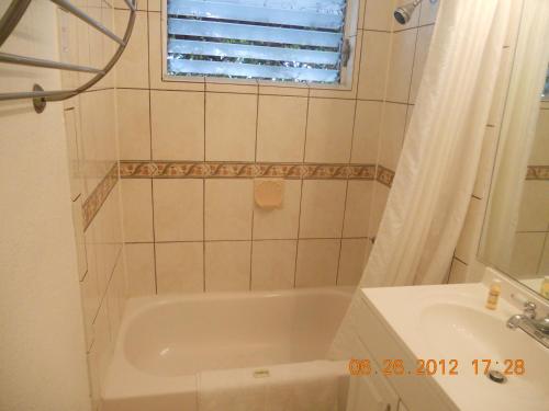 a bathroom with a tub and a sink at Tradewinds Airport Hotel in Inglewood