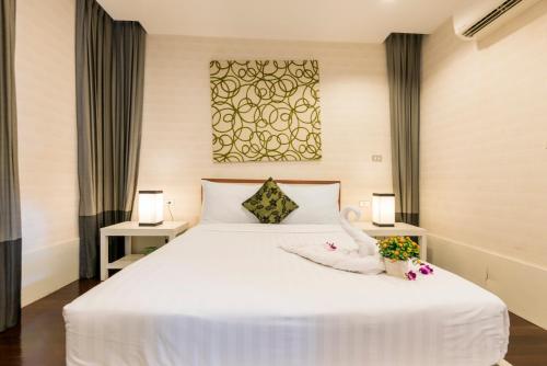 Un dormitorio con una gran cama blanca con flores. en Tropical Garden Paradise Villa, en Na Jomtien