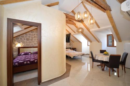 ein Schlafzimmer mit Bett und ein Esszimmer mit Tisch in der Unterkunft Palazzo Max and Alex Apartments in Kotor