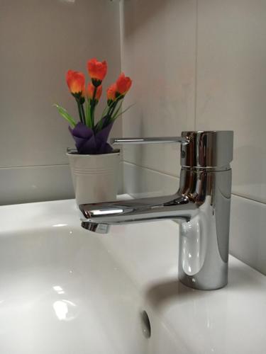 a bathroom sink with a faucet with flowers on it at La Galayca in El Barcenal