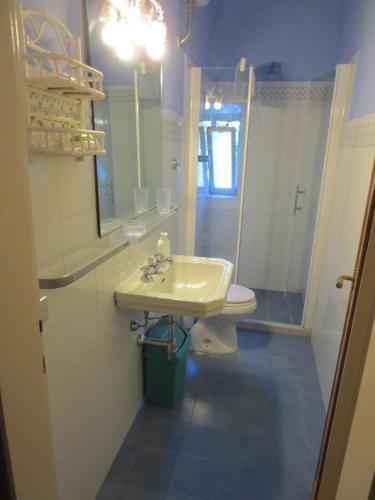 Un baño con lavabo, inodoro y espejo. en Villa vista Fiesole, en Florencia