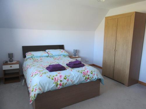 AultbeaにあるTaighali Apartmentのベッドルーム1室(ベッド1台付)、木製キャビネットが備わります。