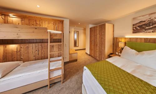 a bedroom with two bunk beds in a room at Alpenhotel Wurzer in Filzmoos