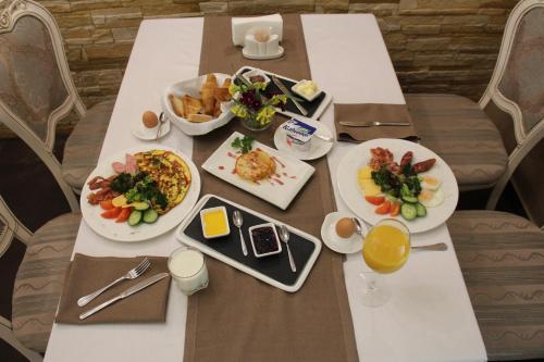 a white table with plates of food on it at Aristokrat in Vinnytsya