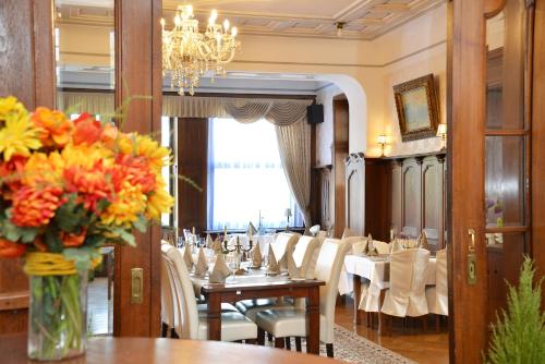 a dining room with tables and chairs and a vase of flowers at Villa Oranien in Diez