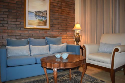 a living room with a blue couch and a table at Altos de Fontana by Macondo Collection in Managua