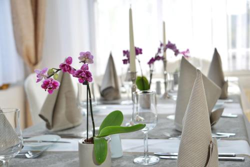 a long table with glasses and purple flowers on it at Villa Oranien in Diez
