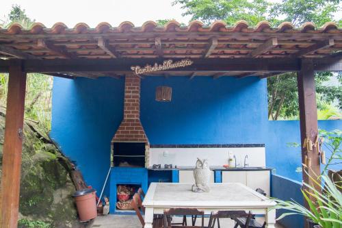 a patio with a blue wall and a pizza oven at Pousada das Pedras in Toque Toque Pequeno