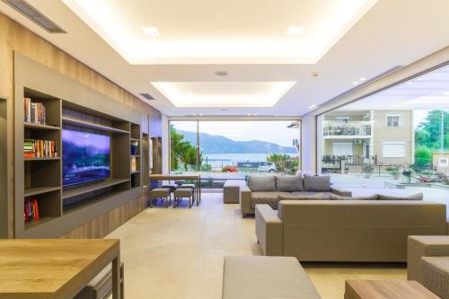 een woonkamer met banken en een tv bij Ntinas Filoxenia Hotel & Spa in Skala Potamias