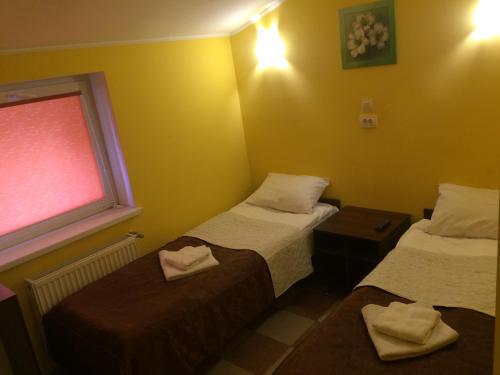 een hotelkamer met 2 bedden en een raam bij Hotel Travel in Lviv