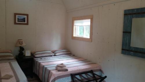 2 camas individuales en una habitación con ventana en DFA Cabin Rentals en Talkeetna