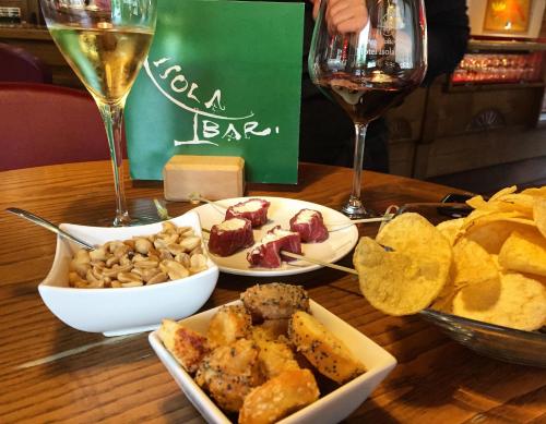 a table with two plates of food and a glass of wine at Hotel Isolabella Wellness in Fiera di Primiero