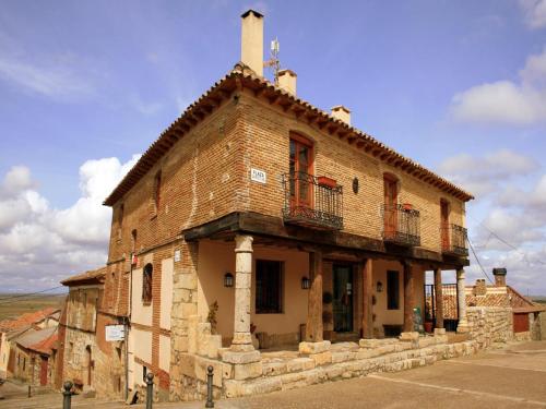 an old brick building with a balcony on a street at Hotel Rural San Hipólito in Támara