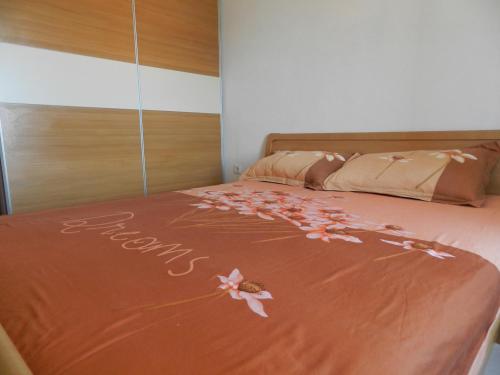 a bed with pink flowers on the bedspread at Apartment Eli in Lumbarda