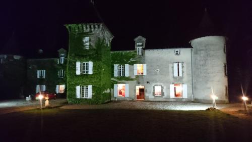 an old building with green ivy on it at night at Pierre Deluen Domaine de la Grange de Quaire in Chassenon