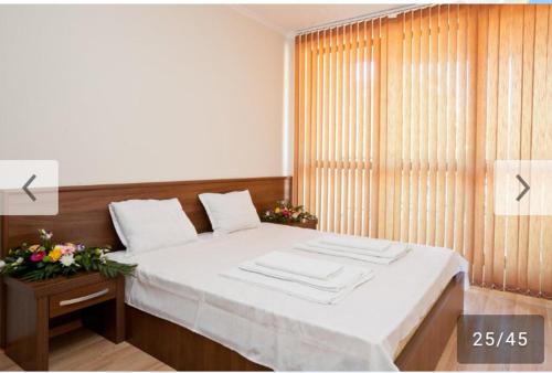サニービーチにあるApartment Boyana Palaceのベッドルーム1室(白いシーツ付きのベッド1台、窓付)