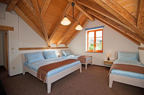 two beds in a room with wooden ceilings at Vila Lednice in Lednice