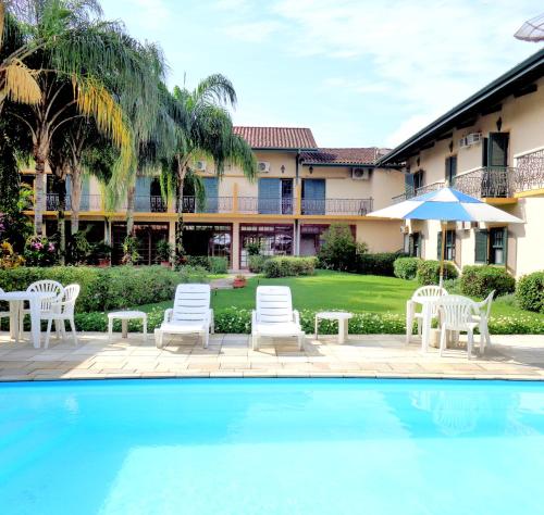 um resort com piscina e cadeiras e um edifício em Pousada Villa Harmonia em Paraty