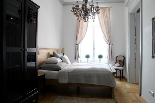 1 dormitorio con cama y lámpara de araña en Leon Apartments, en Leipzig